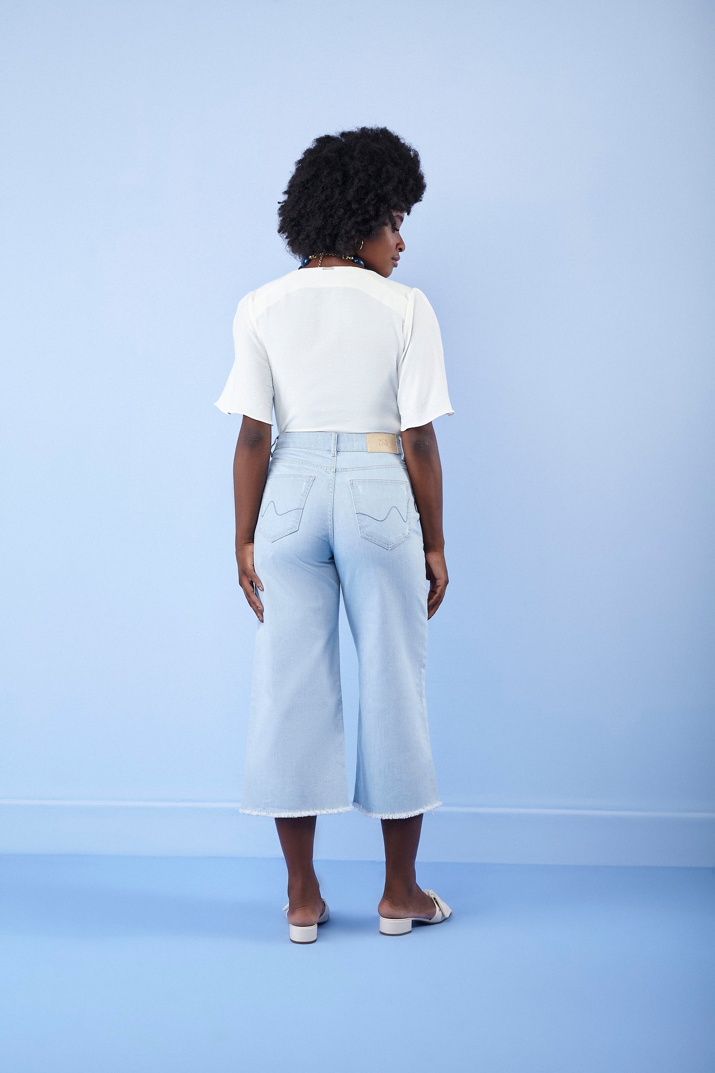 calça jeans pantacourt cintura intermediária com barra desfiada
